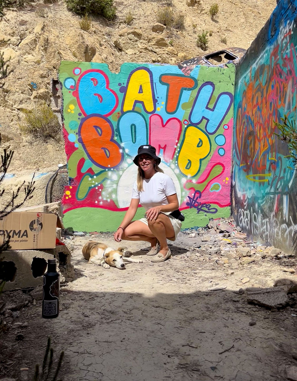 woman with dog sitting in front of graffiti art at Festival Club Ibiza