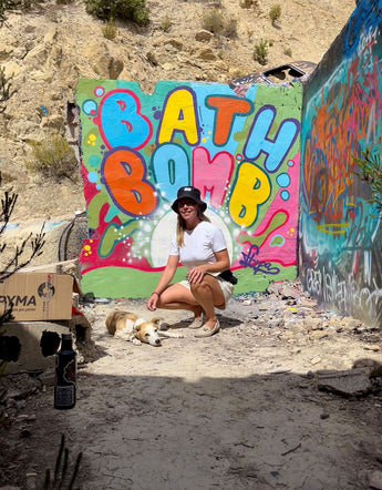 woman with dog sitting in front of graffiti art at Festival Club Ibiza